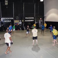 Students engaged in training at the gym, demonstrating various techniques and camaraderie.