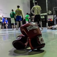 A pair of boxing gloves resting on the gym floor, symbolizing readiness for training and competition.